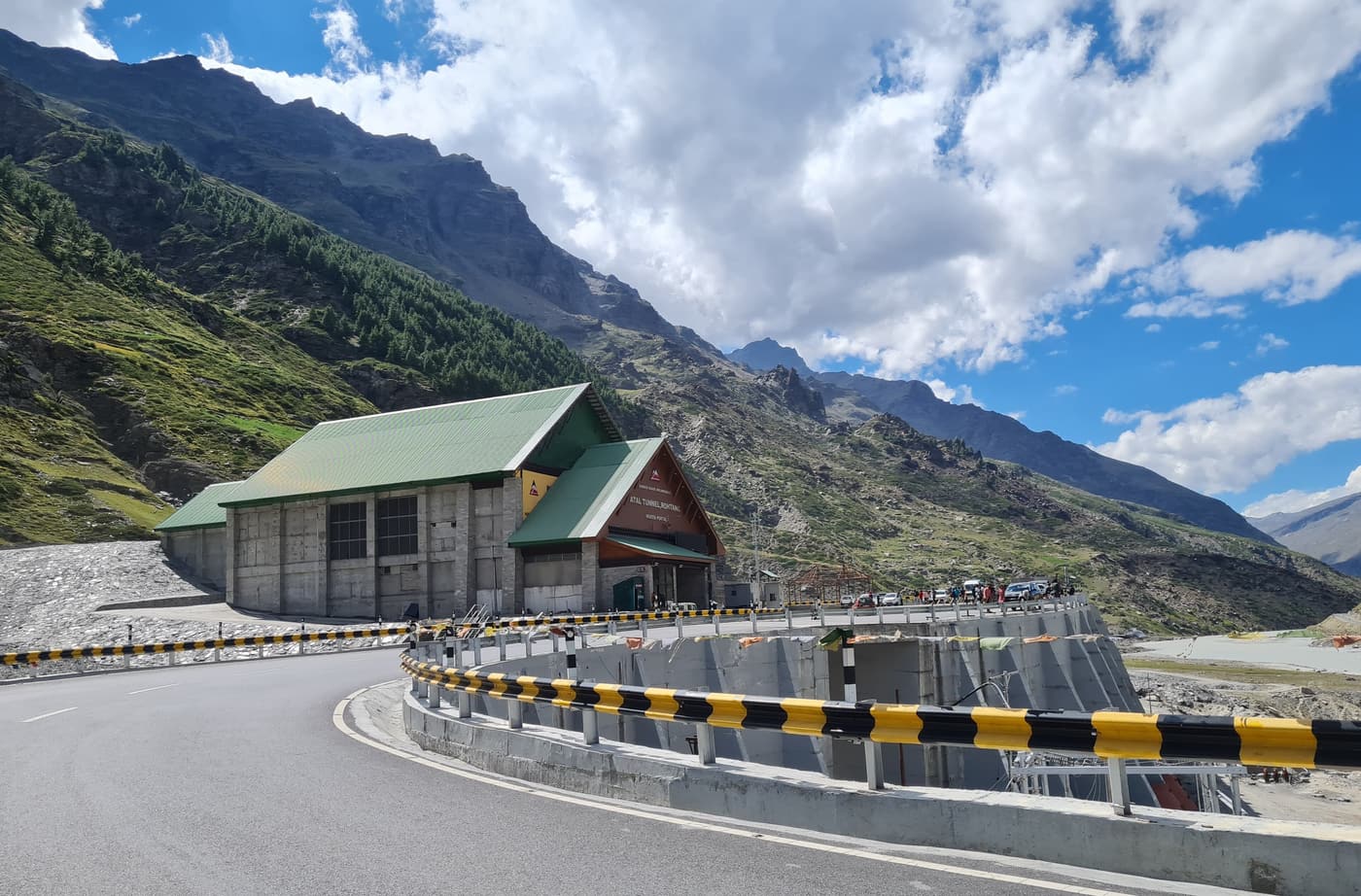 The south portal of the Atal Tunnel below snow-streaked mountains near Manali