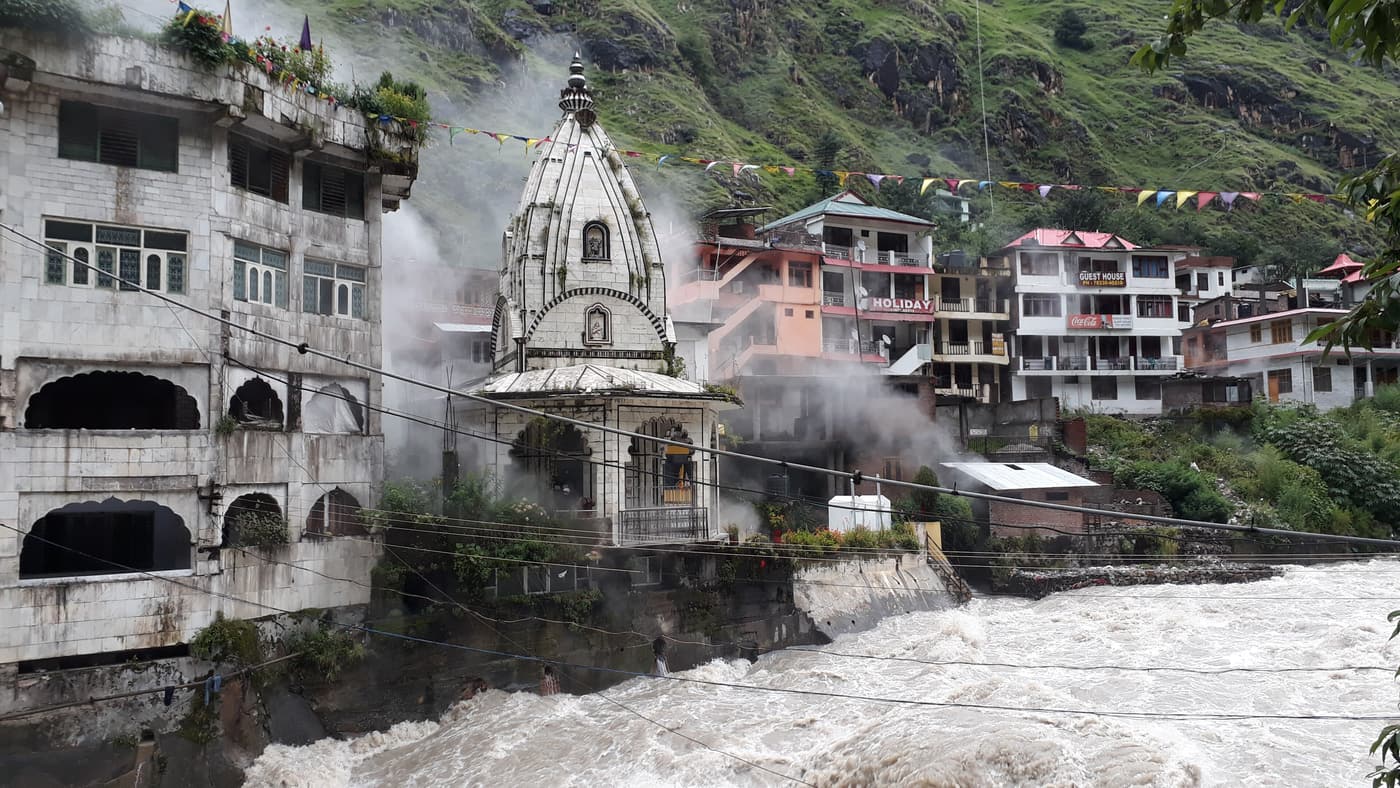 The gurdwara and hot-spring steam at Manikaran above the rushing Parvati river