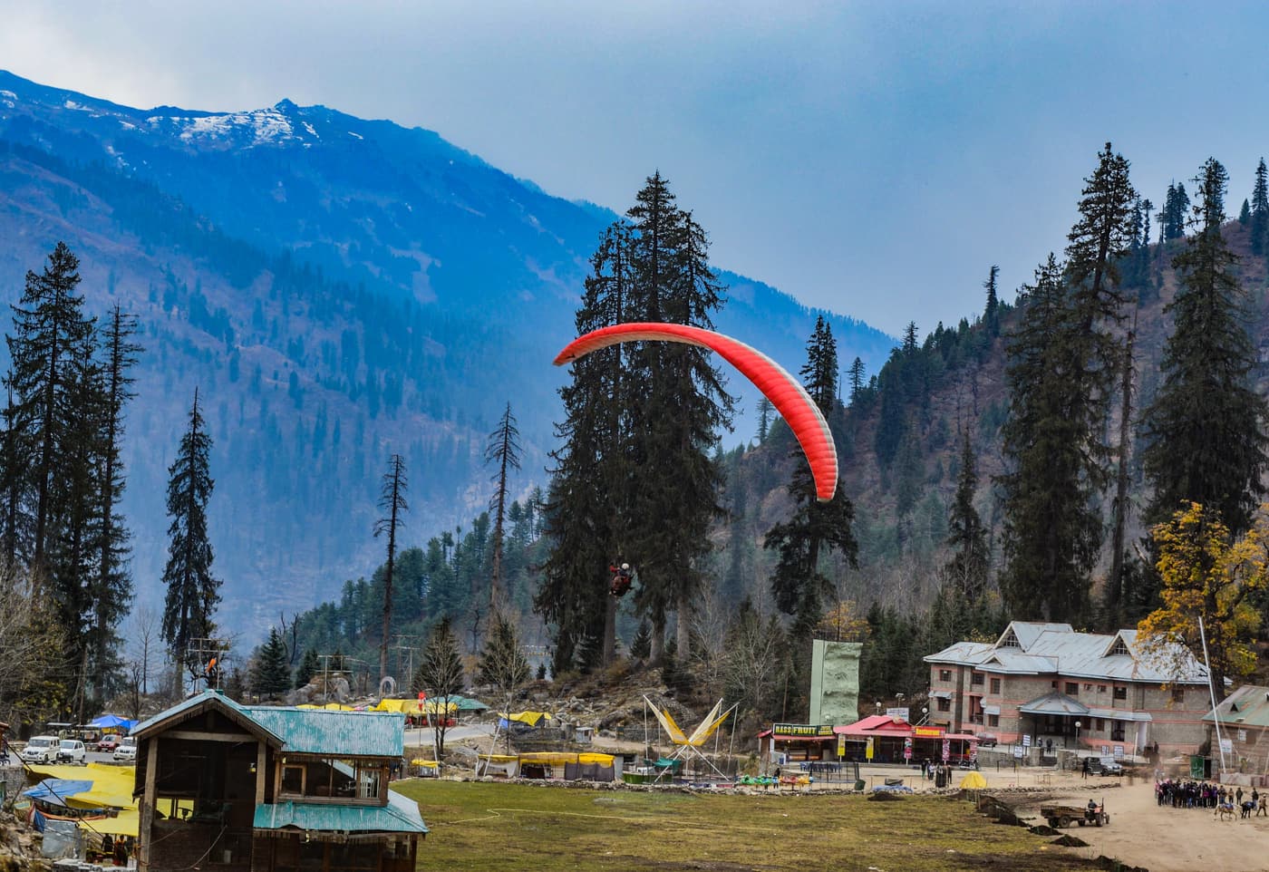 A paraglider over the Solang Valley meadow near Manali